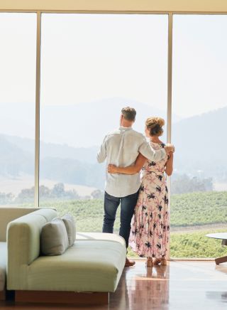 Couple enjoying wine with scenic views across Logan Wines vineyard in Apple Tree Flat, Mudgee