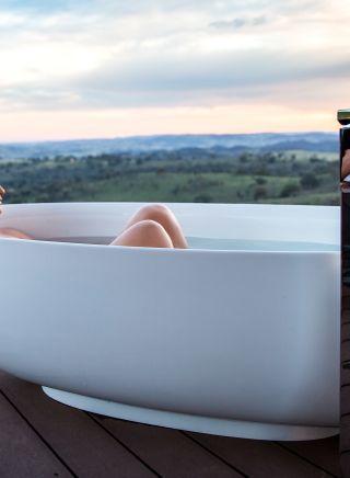 Woman enjoying a relaxing bath with scenic views across the Mudgee countryside from Sierra Escapes, Piambong near Mudgee