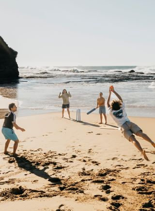 Friends playing cricket on Coledale Beach, Thirroul