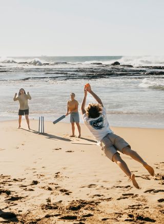 Friends playing cricket on Coledale Beach, Thirroul