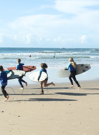 ポート・マッコーリーのフリンズビーチにあるポートマッコーリーサーフスクールでサーフィンを学ぶ人々
