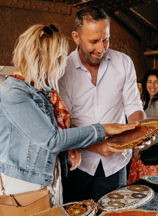 Couple browsing through Aboriginal artwork for sale at the Blak Markets on Bare Island, La Perouse