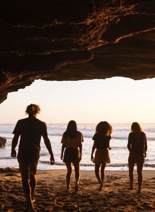  Four friends enjoying a warm sunrise inside cave, Caves Beach, Lake Macquarie