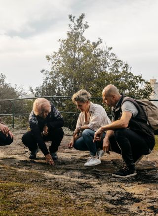 マーガレット・キャンベルがドリームタイム・サザンX体験の一環として、シドニーのブルースポイントにあるブルースポイント自然保護区で燻製儀式を行っている。