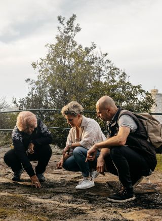 マーガレット・キャンベルがドリームタイム・サザンX体験の一環として、シドニーのブルースポイントにあるブルースポイント自然保護区で燻製儀式を行っている。