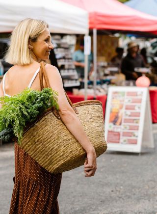Woman enjoying a visit with market basket, Yamba Farmers and Producers Market, Yamba 