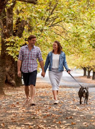 Couple enjoying a walk through tree-lined Sampson Street, Orange