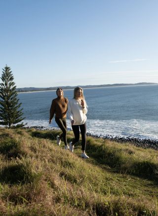 Friends walking across headland, Pat Morton Lookout, Lennox Head
