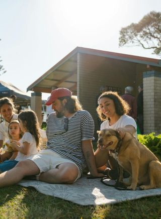 Family sitting on a picnic blanket surrounded by the market stalls, Ballina Farmers and Producers Market, Ballina - Credit: Ballina Farmers and Producers Market