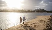 Couple enjoying a walk along Ettalong Beach at sunset