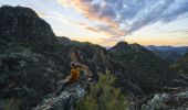 Hiker watching sunset over volcanic rock formations, Warrumbungle National Park