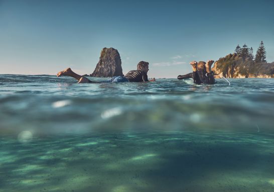 父子俩在南海岸纳鲁马（Narooma）的玻璃屋岩享受早晨冲浪