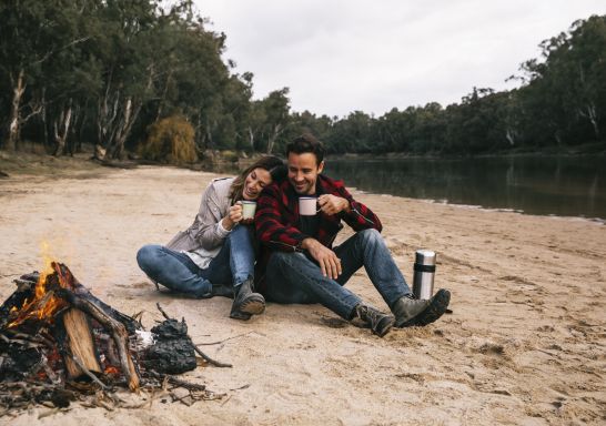 Couple enjoying a camping weekend away on the banks of the Murray River at Ulupna Island, Tocumwal.