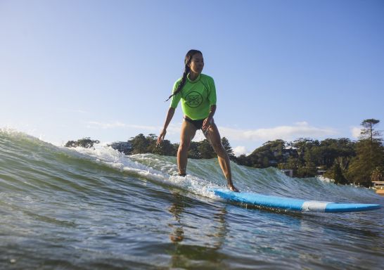 Student enjoying a learn to surf experience with Central Coast Surf Academy, Avoca Beach