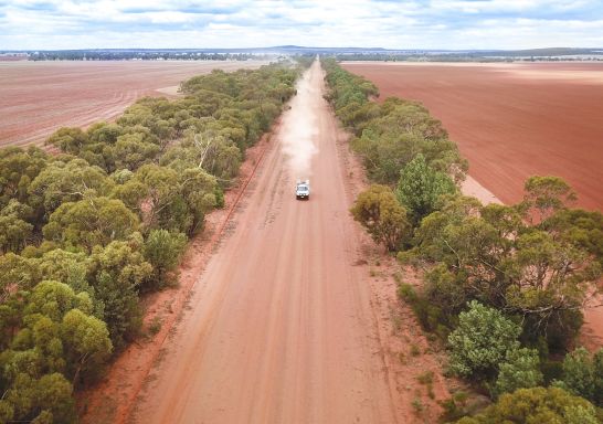 Vehicle travelling along a dirt country road on the outskirts of Hay in Riverina, Country NSW