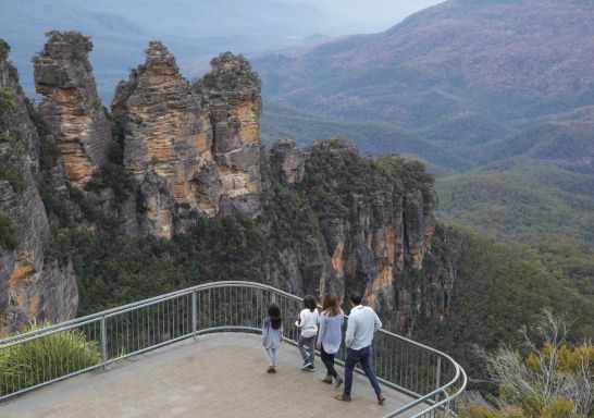Family enjoying views across Blue Mountains National Park to the Three Sisters and Mount Solitary from Echo Point Lookout
