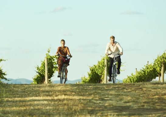 Couple enjoying a bike ride around the Clonakilla Wines vineyard in Murrumbateman