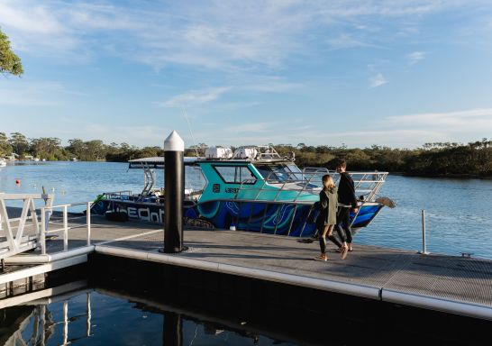 朋友們走在碼頭上，準備乘船賞鯨，並與海豹一起游泳，地點是杰維斯海灣（Jervis Bay）的沃比根潛水中心。