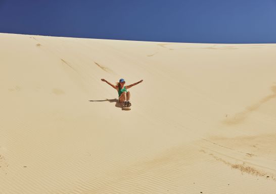 Woman surfs the dunes, Sand Dune Safaris, Anna Bay 